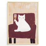 Indlæs billede til gallerivisning Funny cat art print plakat showing a white cat sitting on a maroon chair holding a wine glass, framed in black on a beige background.
