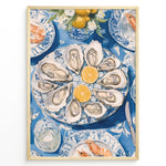 Indlæs billede til gallerivisning Oyster platter art print plakat showing oysters and lemon slices on a blue patterned table with seafood dishes and glassware in a Golden frame.
