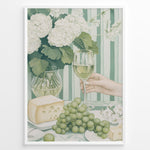 Indlæs billede til gallerivisning Elegant art print plakat of white wine glass, grapes, cheese, and hydrangeas on a green striped table with a hand holding a wine glass in a white frame.
