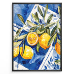 Indlæs billede til gallerivisning Mediterranean lemon wall art with yellow lemons and olive leaves on blue and white tile background, framed in black, ideal for kitchen or dining room décor.
