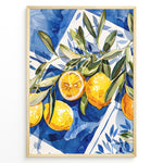 Indlæs billede til gallerivisning Mediterranean lemon wall art with yellow lemons and olive leaves on blue and white tile background, framed in black, ideal for kitchen or dining room décor.
