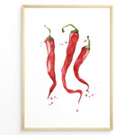 Indlæs billede til gallerivisning Watercolor plakat illustration of three red chili peppers with green stems and paint splatters, framed in black, ideal for modern kitchen or dining room décor.
