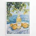 Indlæs billede til gallerivisning Limoncello art print plakat with a bottle of limoncello, lemons, and green leaves overlooking the blue sea on a striped tablecloth in a white frame.
