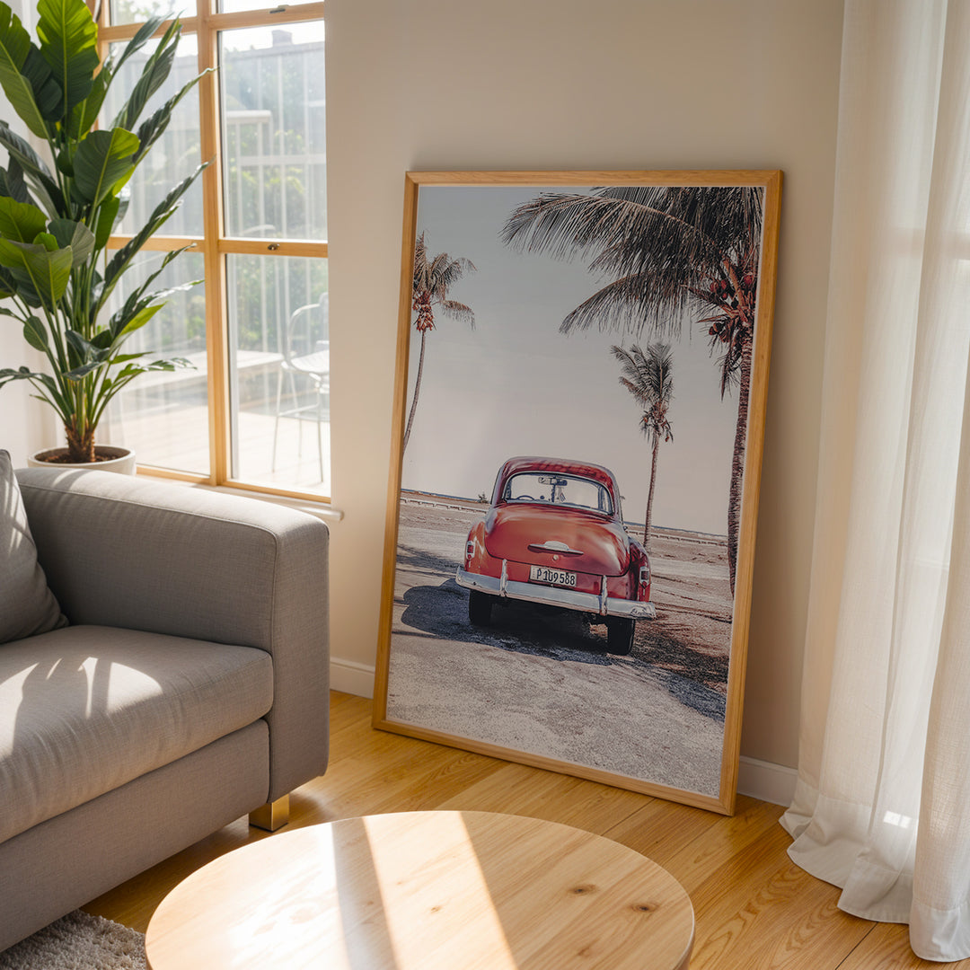 Plakat med vintage bil | Sommer og Strand Plakater | Denne plakat viser en vintage rød bil parkeret ved en strandvej med havet og palmetræer i baggrunden. Perfekt til dem, der elsker retro og strandstemning.