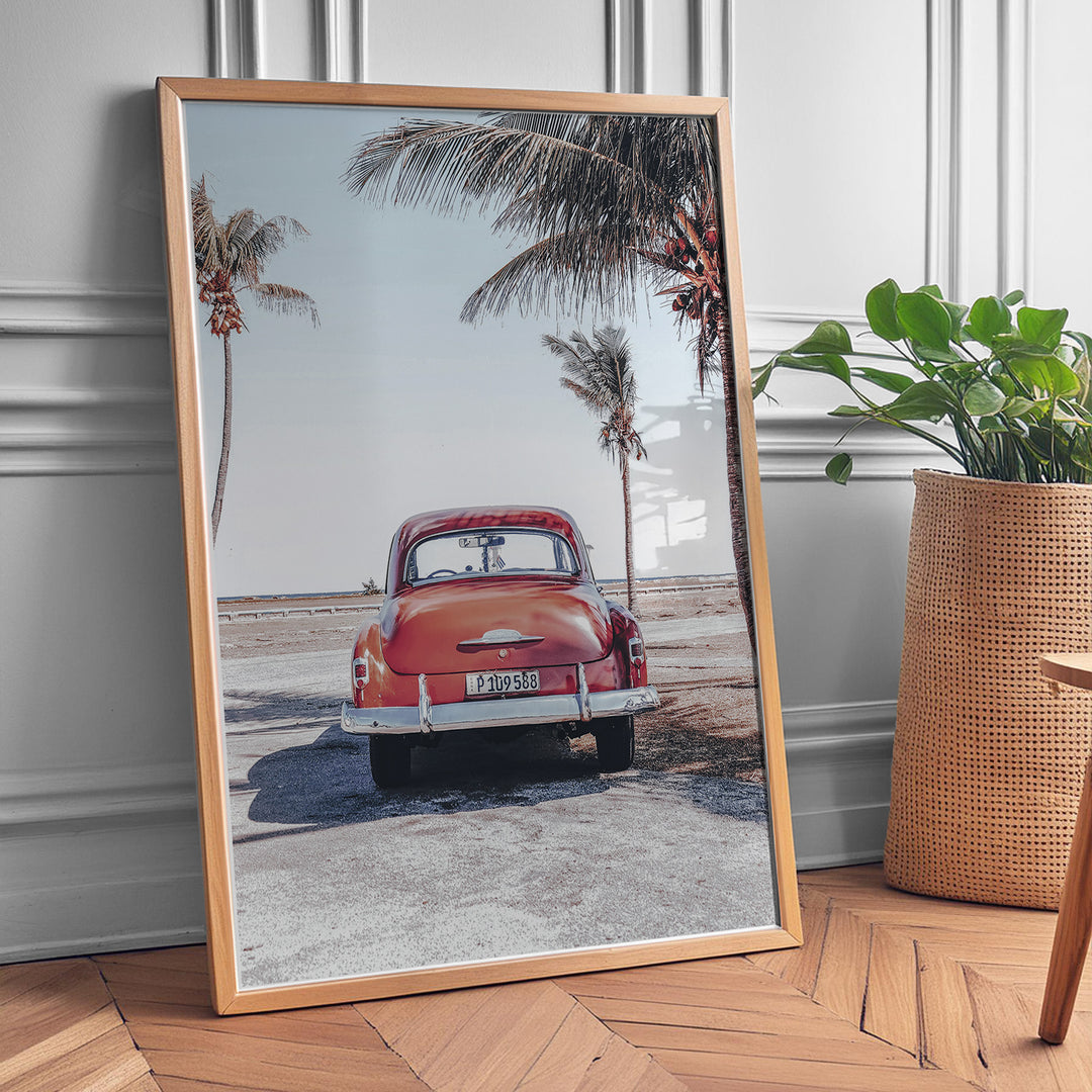 Plakat med vintage bil | Sommer og Strand Plakater | Denne plakat viser en vintage rød bil parkeret ved en strandvej med havet og palmetræer i baggrunden. Perfekt til dem, der elsker retro og strandstemning.