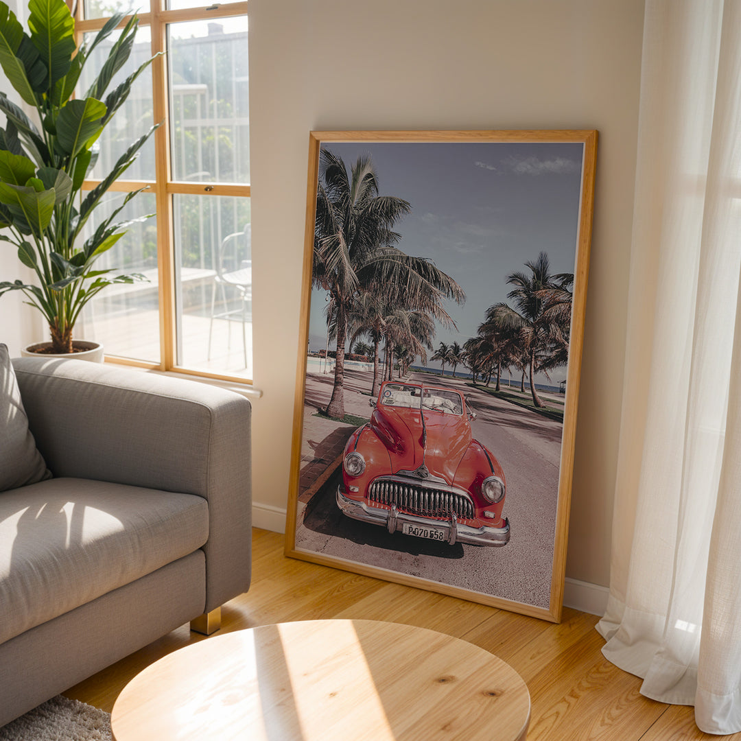 Plakat med vintage rød bil | Sommer og Strand Plakater | Denne plakat viser en klassisk rød cabriolet parkeret på en gade med palmer ved stranden. Perfekt til retro- og strandelskere.