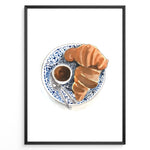 Indlæs billede til gallerivisning Watercolor wall art of a croissant and espresso cup on a blue decorative plate, ideal for French café, kitchen, or breakfast nook wall décor.
