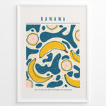 Indlæs billede til gallerivisning Colorful banana art print plakat with abstract teal and yellow shapes, text reading “Life is better with a bunch of bananas,” framed in white.
