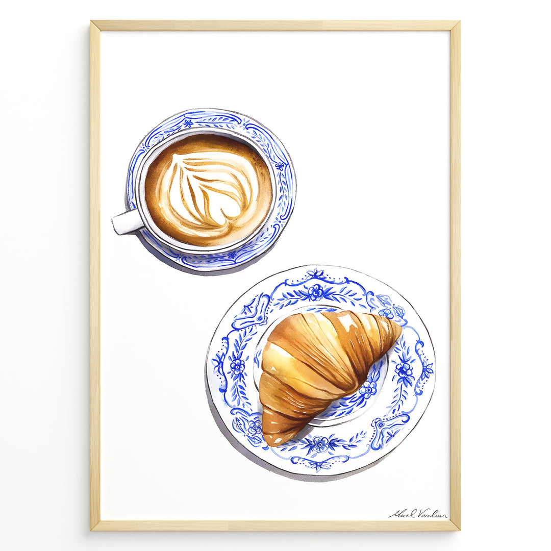 Art print of a cappuccino and croissant on blue patterned plates — French café-style kitchen wall décor.