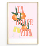 Indlæs billede til gallerivisning Stylish La Dolce Vita poster with oranges, green leaves, and champagne glasses on a pink background, framed as Italian-inspired wall art.
