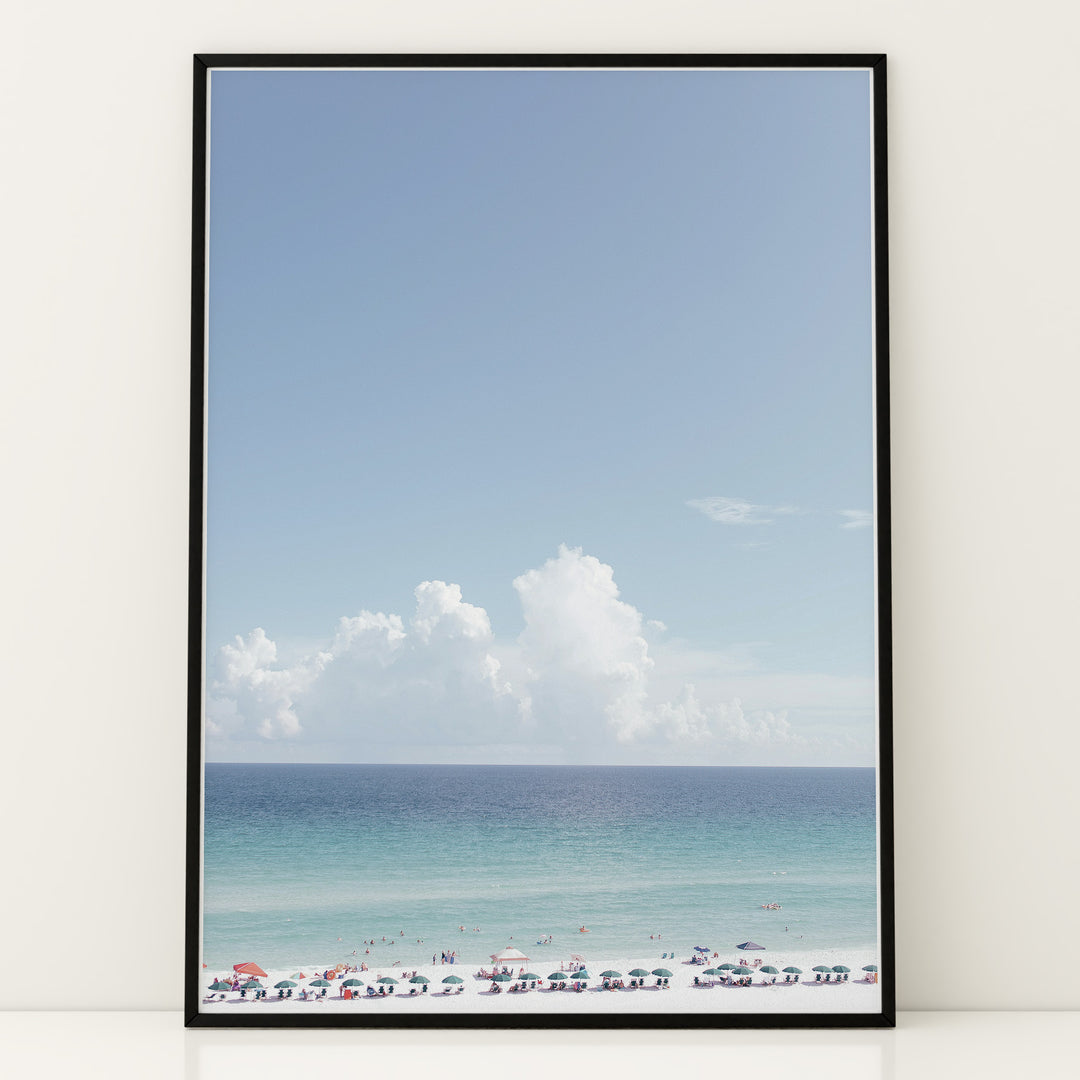 Plakat med strandparadis | Sommer og Strand Plakater | Denne plakat viser en smuk strandscene med et klart blåt hav, farverige parasoller og mennesker, der nyder solen og vandet. Perfekt til dem, der elsker strandliv og afslapning.