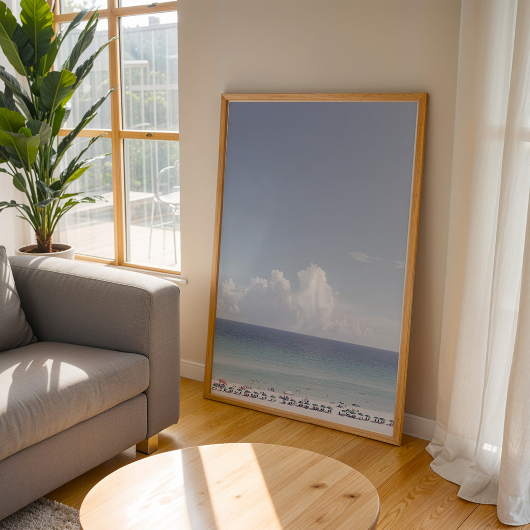 Plakat med strandparadis | Sommer og Strand Plakater | Denne plakat viser en smuk strandscene med et klart blåt hav, farverige parasoller og mennesker, der nyder solen og vandet. Perfekt til dem, der elsker strandliv og afslapning.