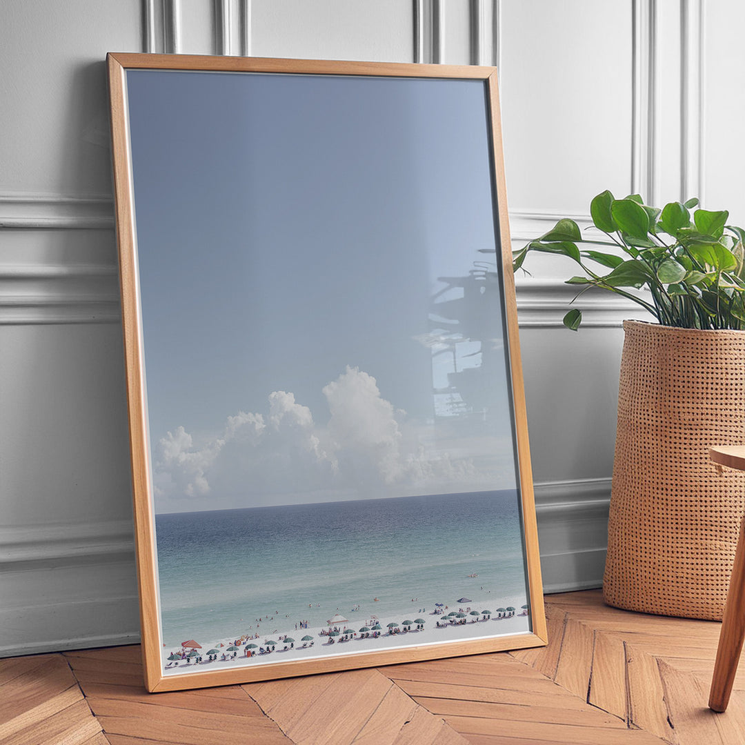 Plakat med strandparadis | Sommer og Strand Plakater | Denne plakat viser en smuk strandscene med et klart blåt hav, farverige parasoller og mennesker, der nyder solen og vandet. Perfekt til dem, der elsker strandliv og afslapning.