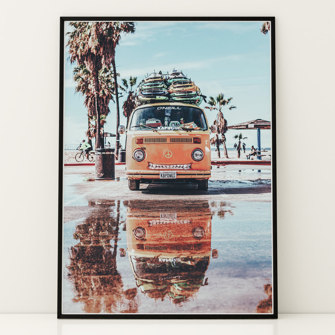 Plakat med Volkswagen surf van | Sommer og Strand Plakater | Denne plakat viser en orange Volkswagen van med surfbrætter på taget, parkeret på en våd overflade med refleksion af vanen i vandet. Perfekt til eventyrlystne sjæle og strandelskere.