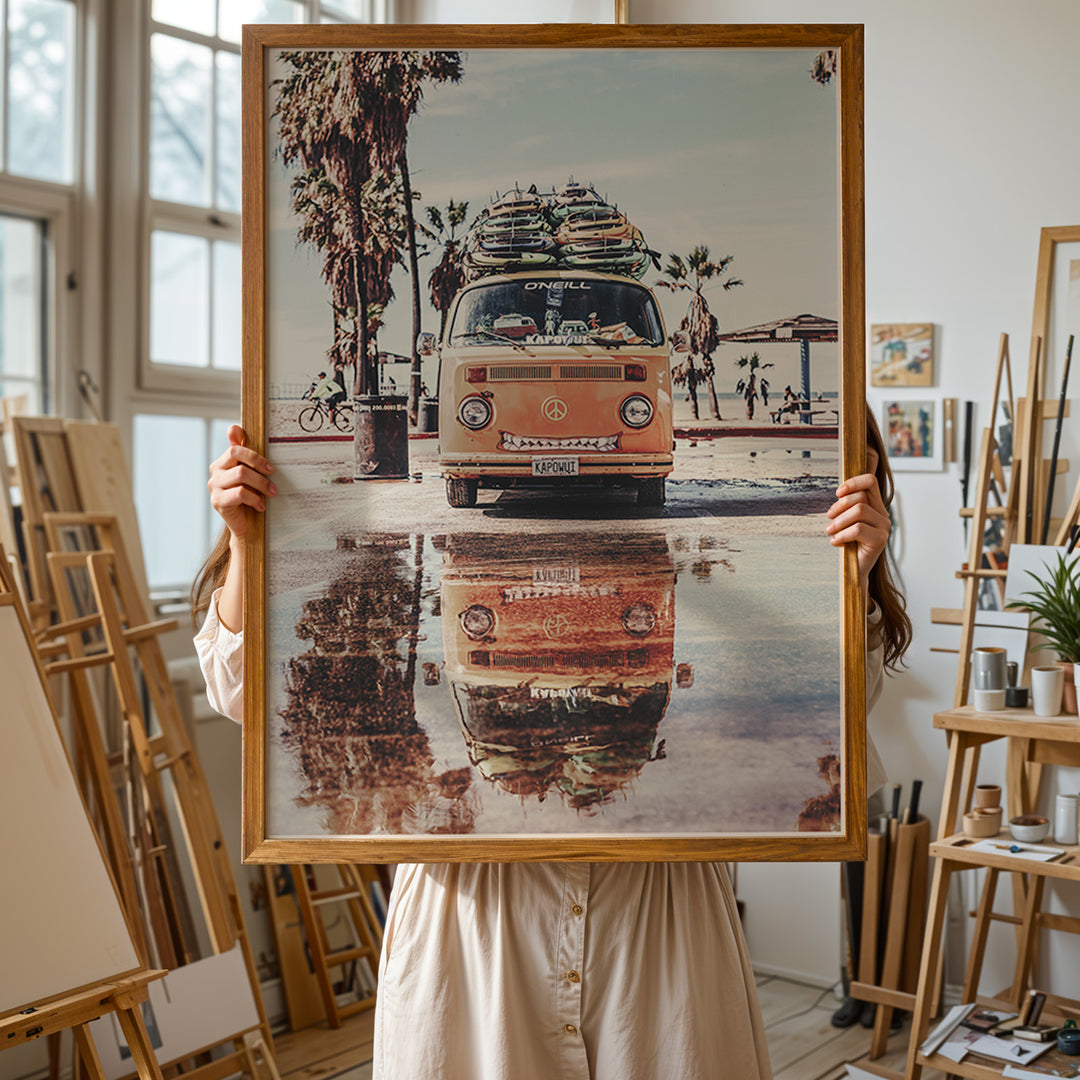 Plakat med Volkswagen surf van | Sommer og Strand Plakater | Denne plakat viser en orange Volkswagen van med surfbrætter på taget, parkeret på en våd overflade med refleksion af vanen i vandet. Perfekt til eventyrlystne sjæle og strandelskere.