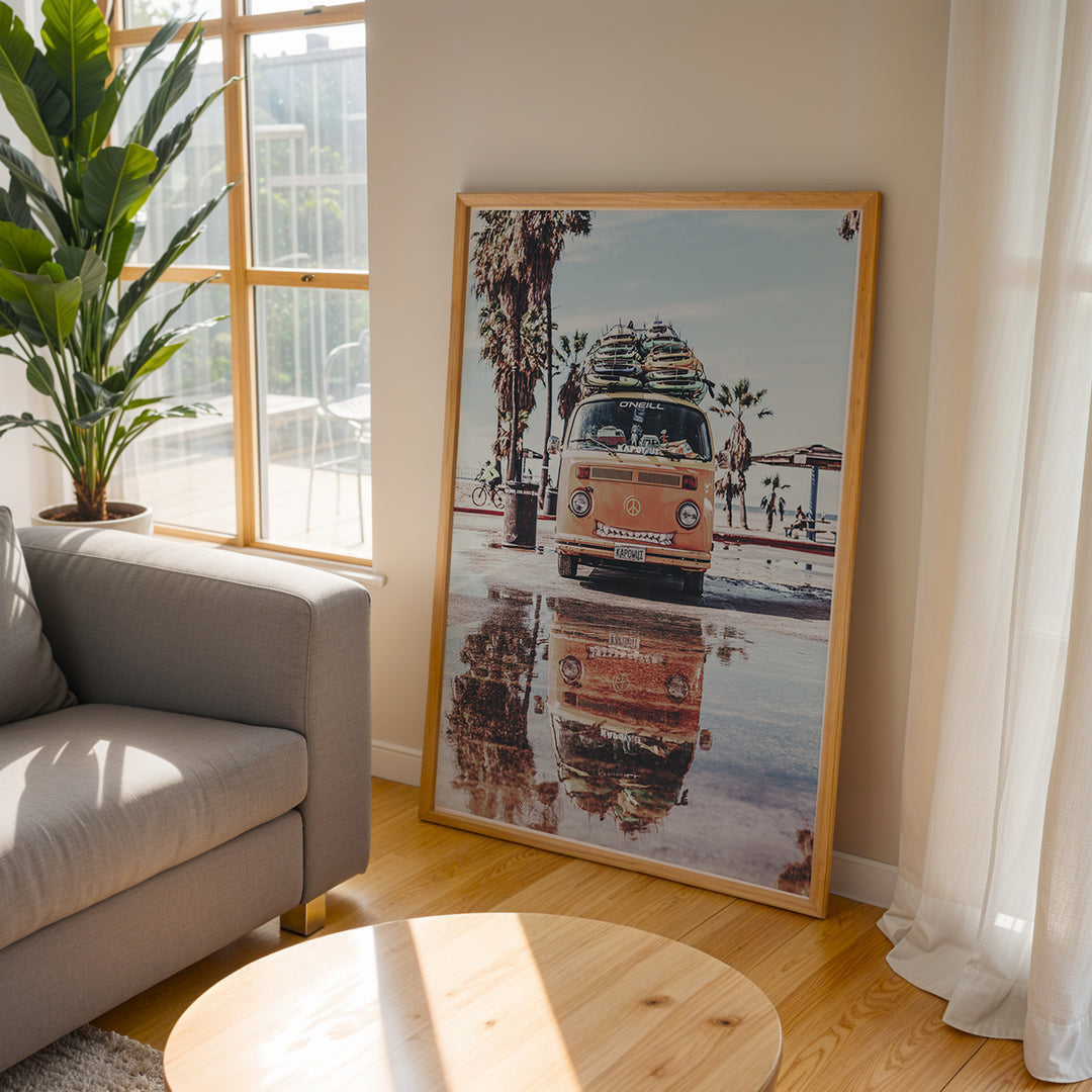 Plakat med Volkswagen surf van | Sommer og Strand Plakater | Denne plakat viser en orange Volkswagen van med surfbrætter på taget, parkeret på en våd overflade med refleksion af vanen i vandet. Perfekt til eventyrlystne sjæle og strandelskere.