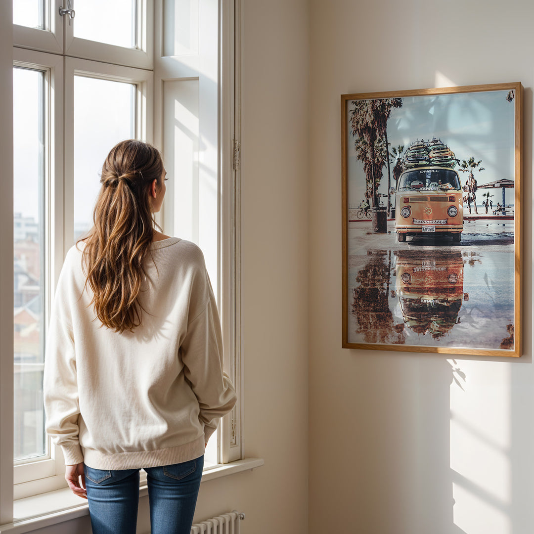 Plakat med Volkswagen surf van | Sommer og Strand Plakater | Denne plakat viser en orange Volkswagen van med surfbrætter på taget, parkeret på en våd overflade med refleksion af vanen i vandet. Perfekt til eventyrlystne sjæle og strandelskere.