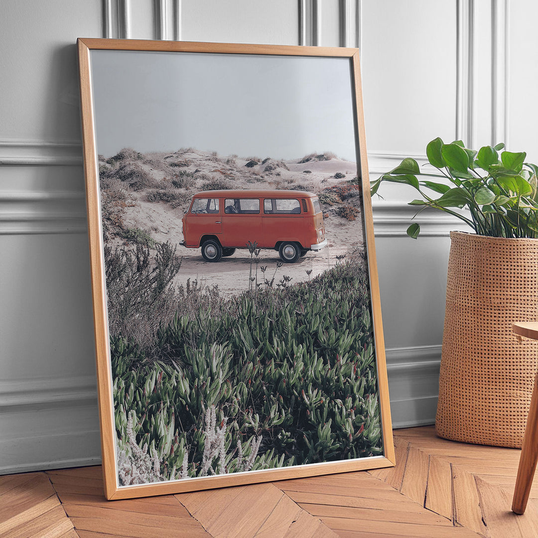 Plakat med vintage van i klitterne | Sommer og Strand Plakater | Denne plakat viser en rød vintage van parkeret på en sandsti omgivet af klitter og vegetation. Perfekt til nostalgikere og eventyrere.