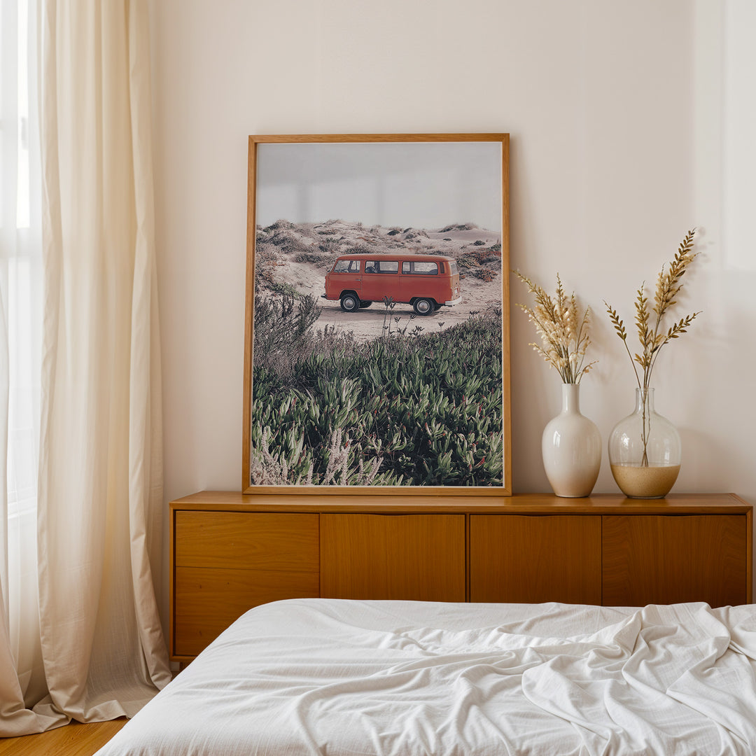 Plakat med vintage van i klitterne | Sommer og Strand Plakater | Denne plakat viser en rød vintage van parkeret på en sandsti omgivet af klitter og vegetation. Perfekt til nostalgikere og eventyrere.