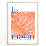 Indlæs billede til gallerivisning Le Matin poster with minimalist croissant illustration in orange and blue text on a white background in a golden frame.
