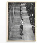 Indlæs billede til gallerivisning Fashion Plakat | Black &amp; White Fashion Runway – Editorial Wall Art Print Plakaty.dk | Black and white photograph of runway models walking in a single-file line during a fashion show, with seated spectators on one side of the runway.
