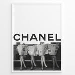 Indlæs billede til gallerivisning Fashion Plakat | CHANEL Newspaper Bench – Fashion Art Poster Plakaty.dk | Black and white fashion poster of four women sitting on a bench reading newspapers, with the bold text &quot;CHANEL&quot; across the top half of the image.
