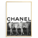 Indlæs billede til gallerivisning Fashion Plakat | CHANEL Newspaper Bench – Fashion Art Poster Plakaty.dk | Black and white fashion poster of four women sitting on a bench reading newspapers, with the bold text &quot;CHANEL&quot; across the top half of the image.
