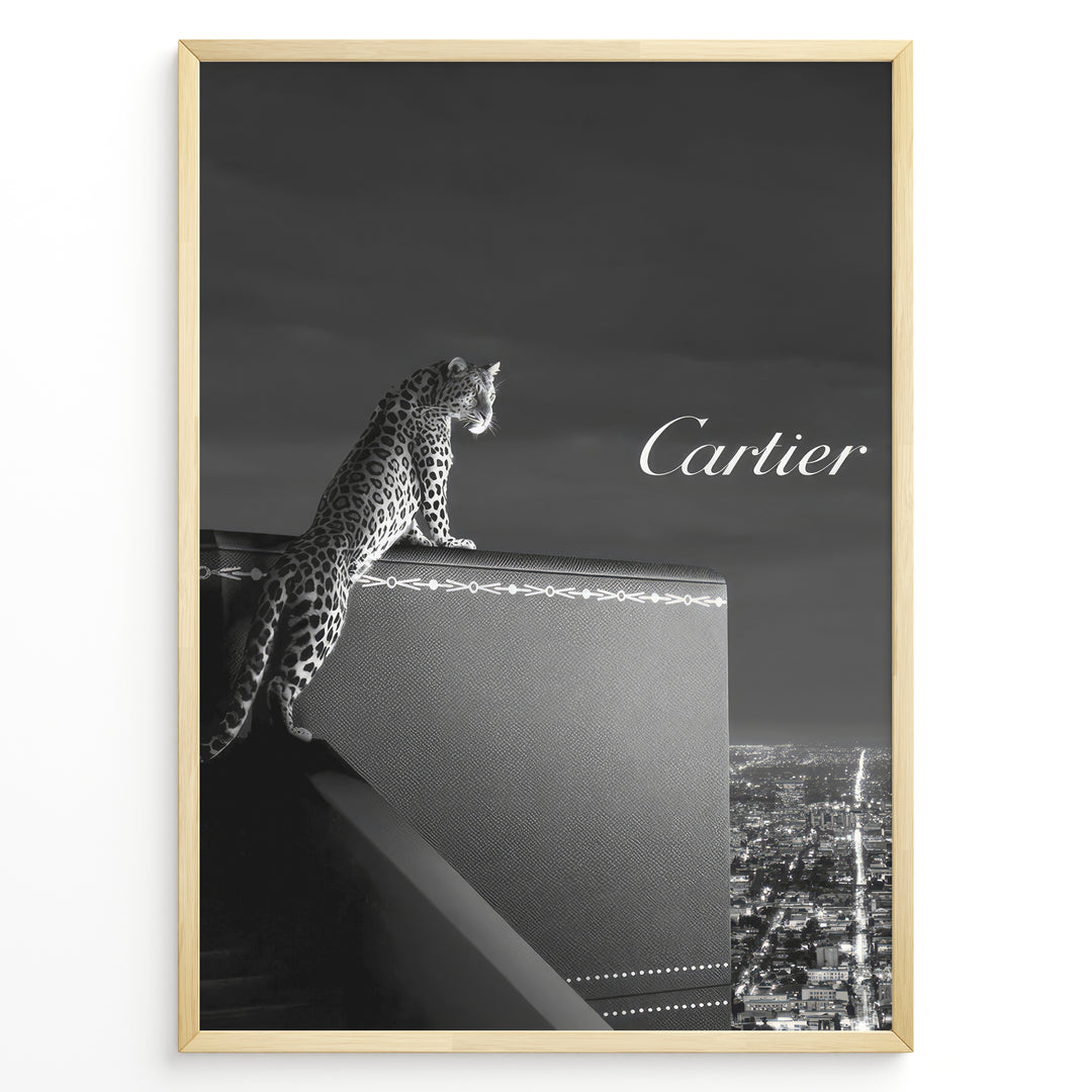 Fashion Plakat | Cartier Panther Over the City: Iconic Elegance in Monochrome Plakaty.dk | Black and white image of a panther perched on a Cartier box overlooking a city skyline at night, with the Cartier logo in the sky.