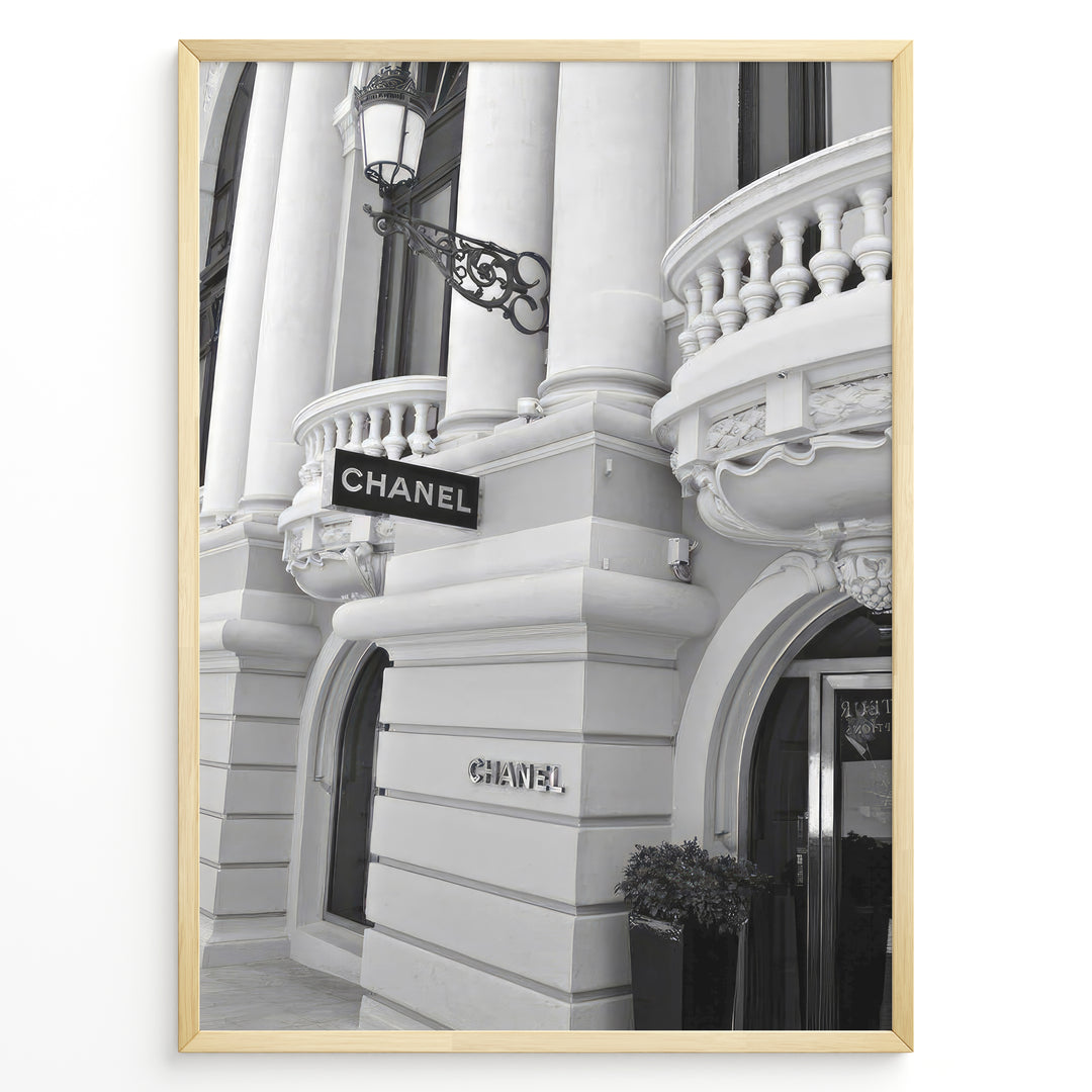 Fashion Plakat | Chanel Boutique Exterior – Monte Carlo, Monaco Plakaty.dk | Black and white photo of the Chanel storefront in Monte Carlo, Monaco, showcasing ornate architecture with columns, balconies, and a hanging sign.