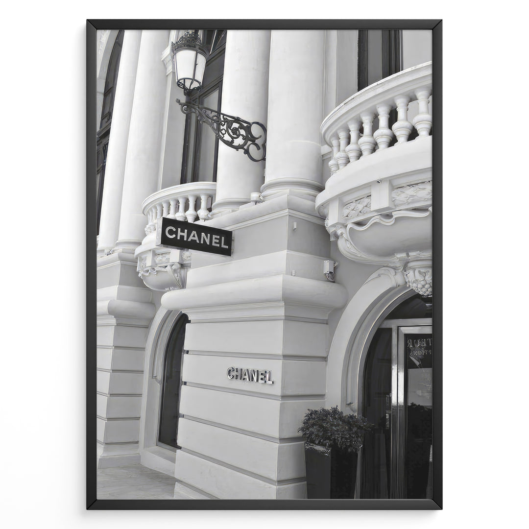 Fashion Plakat | Chanel Boutique Exterior – Monte Carlo, Monaco Plakaty.dk | Black and white photo of the Chanel storefront in Monte Carlo, Monaco, showcasing ornate architecture with columns, balconies, and a hanging sign.