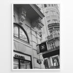 Indlæs billede til gallerivisning Fashion Plakat | Chanel Boutique Vienna Black &amp; White Architectural Poster Plakaty.dk | Black and white photo of a Chanel store in a European city with ornate architecture and a Chanel flag sign.
