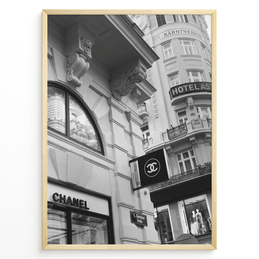 Fashion Plakat | Chanel Boutique Vienna Black & White Architectural Poster Plakaty.dk | Black and white photo of a Chanel store in a European city with ornate architecture and a Chanel flag sign.