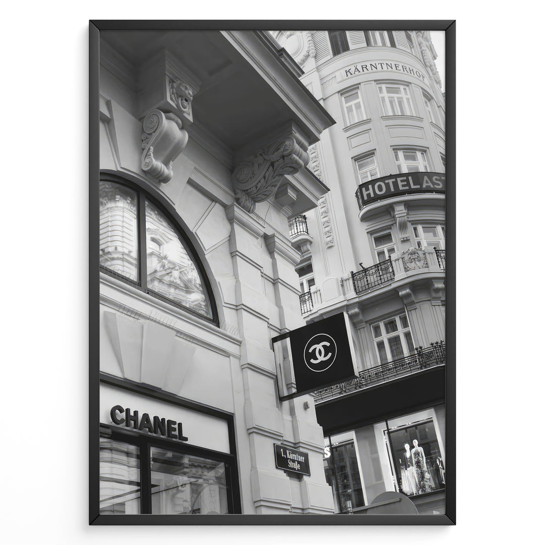 Fashion Plakat | Chanel Boutique Vienna Black & White Architectural Poster Plakaty.dk | Black and white photo of a Chanel store in a European city with ornate architecture and a Chanel flag sign.