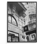Indlæs billede til gallerivisning Fashion Plakat | Chanel Boutique Vienna Black &amp; White Architectural Poster Plakaty.dk | Black and white photo of a Chanel store in a European city with ornate architecture and a Chanel flag sign.

