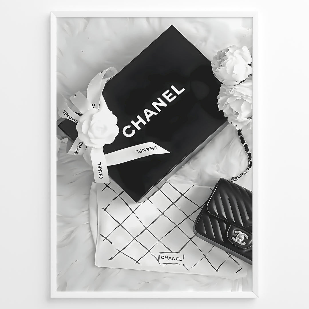 Fashion Plakat | Chanel Gift Box & Handbag Flatlay Wall Art Plakaty.dk | Black and white flatlay of a Chanel gift box with ribbon, camellia flowers, and a quilted Chanel handbag on a soft surface.