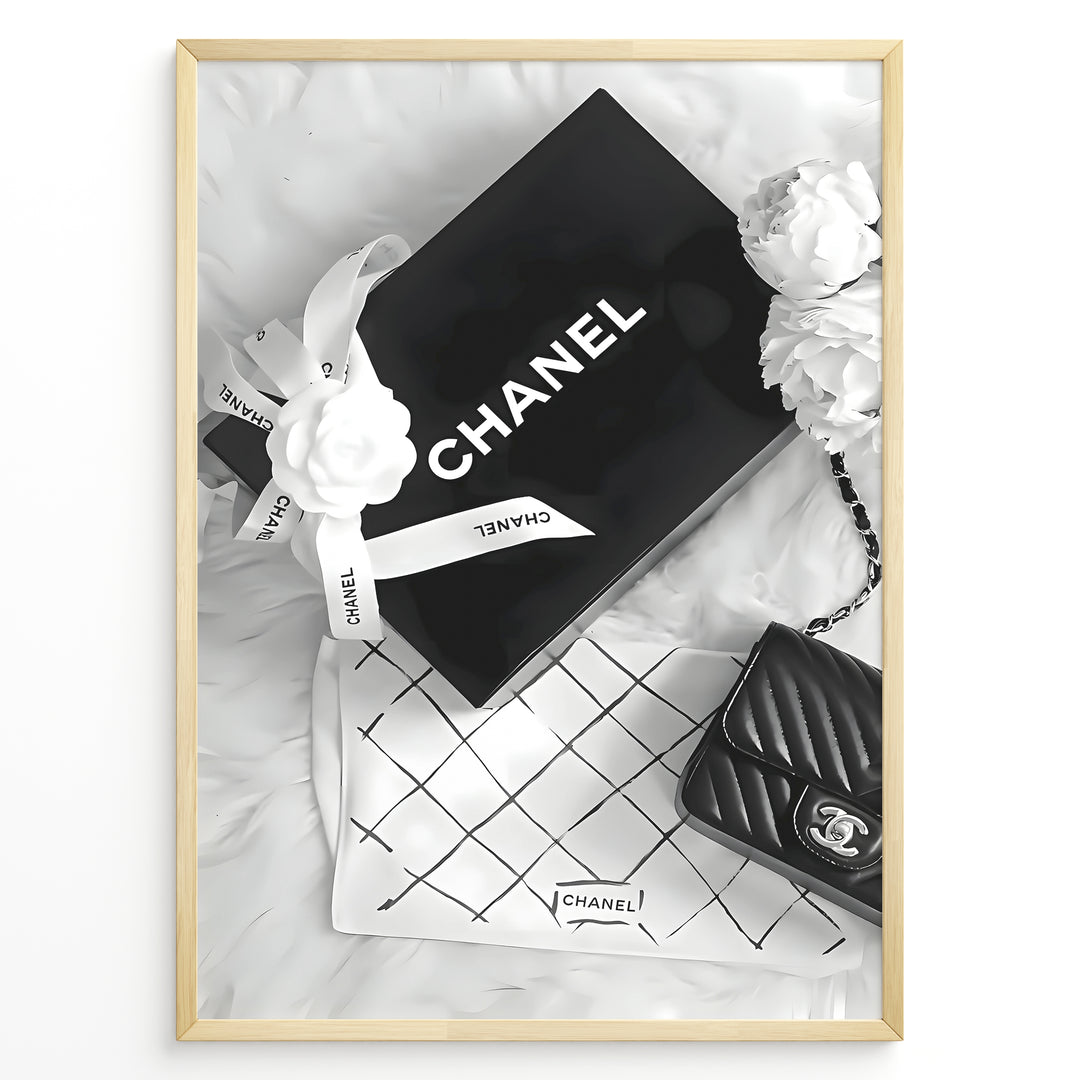 Fashion Plakat | Chanel Gift Box & Handbag Flatlay Wall Art Plakaty.dk | Black and white flatlay of a Chanel gift box with ribbon, camellia flowers, and a quilted Chanel handbag on a soft surface.
