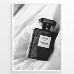 Indlæs billede til gallerivisning Fashion Plakat | Chanel No. 5 L’Eau Perfume Bottle – Black and White Fashion Photography Plakaty.dk | Black and white photo of a Chanel No. 5 L’Eau perfume bottle resting on a bed of soft white fabric.
