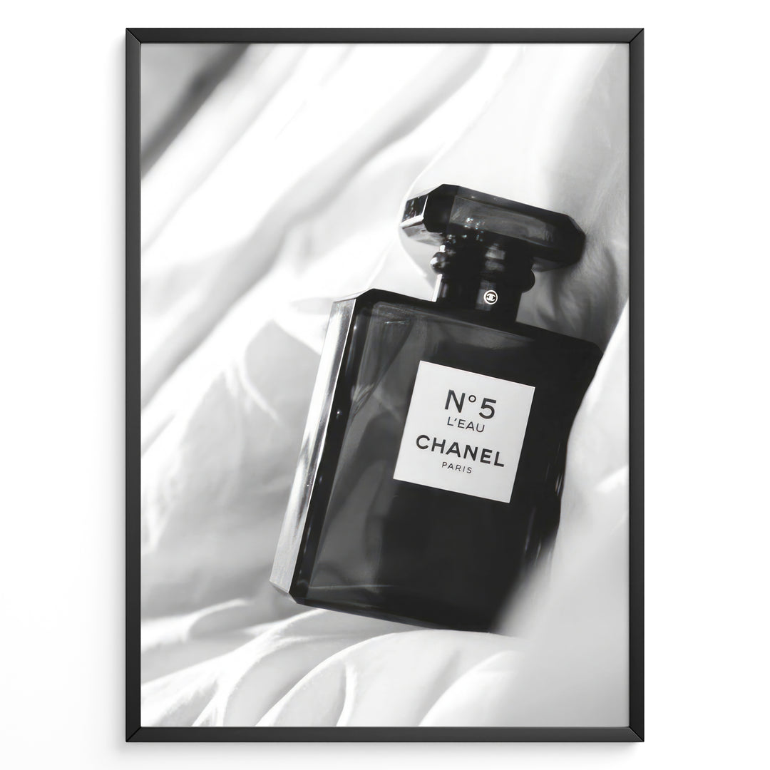Fashion Plakat | Chanel No. 5 L’Eau Perfume Bottle – Black and White Fashion Photography Plakaty.dk | Black and white photo of a Chanel No. 5 L’Eau perfume bottle resting on a bed of soft white fabric.