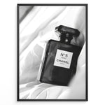 Indlæs billede til gallerivisning Fashion Plakat | Chanel No. 5 L’Eau Perfume Bottle – Black and White Fashion Photography Plakaty.dk | Black and white photo of a Chanel No. 5 L’Eau perfume bottle resting on a bed of soft white fabric.
