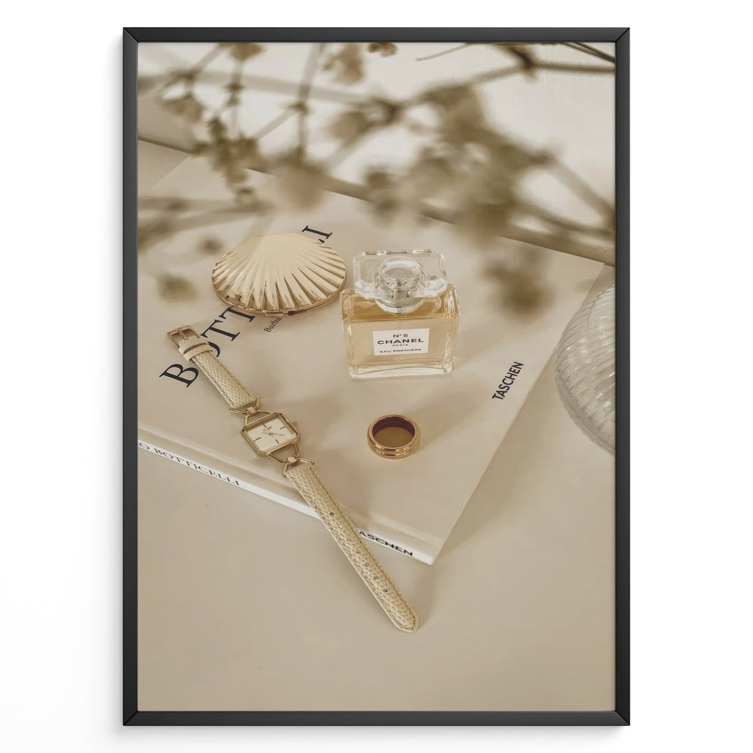 Fashion Plakat | Chanel No. 5 Perfume Flat Lay with Watch and Books – Neutral Aesthetic Print Plakaty.dk | Flat lay of Chanel No. 5 perfume bottle, gold watch, ring, and decorative shell on fashion books with soft floral blur in neutral tones.