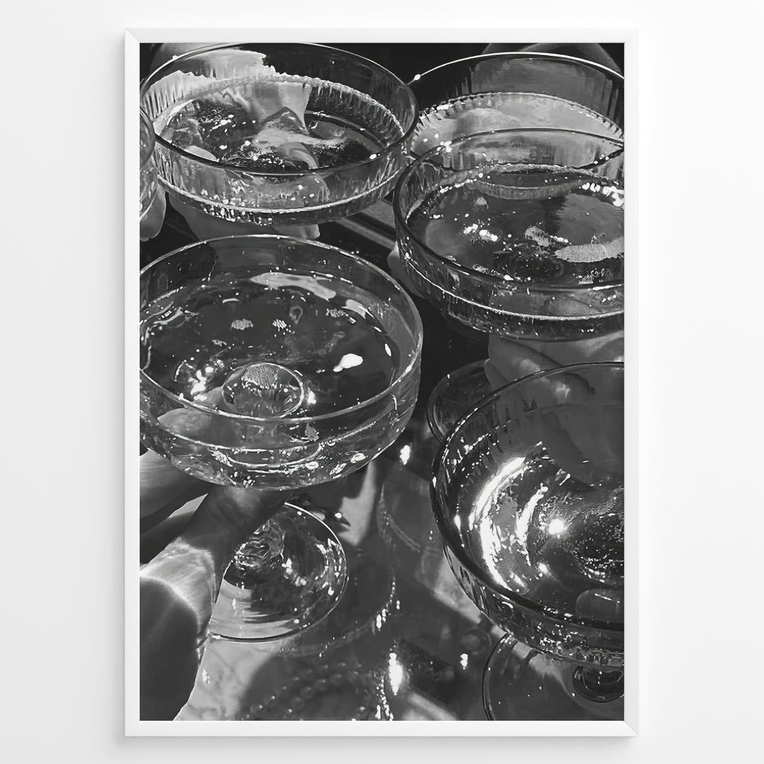 Fashion Plakat | Cheers in Black & White: Luxe Champagne Coupes Wall Art Plakaty.dk | Black and white photo of multiple champagne coupe glasses being raised in a celebratory toast, reflecting light and bubbles.