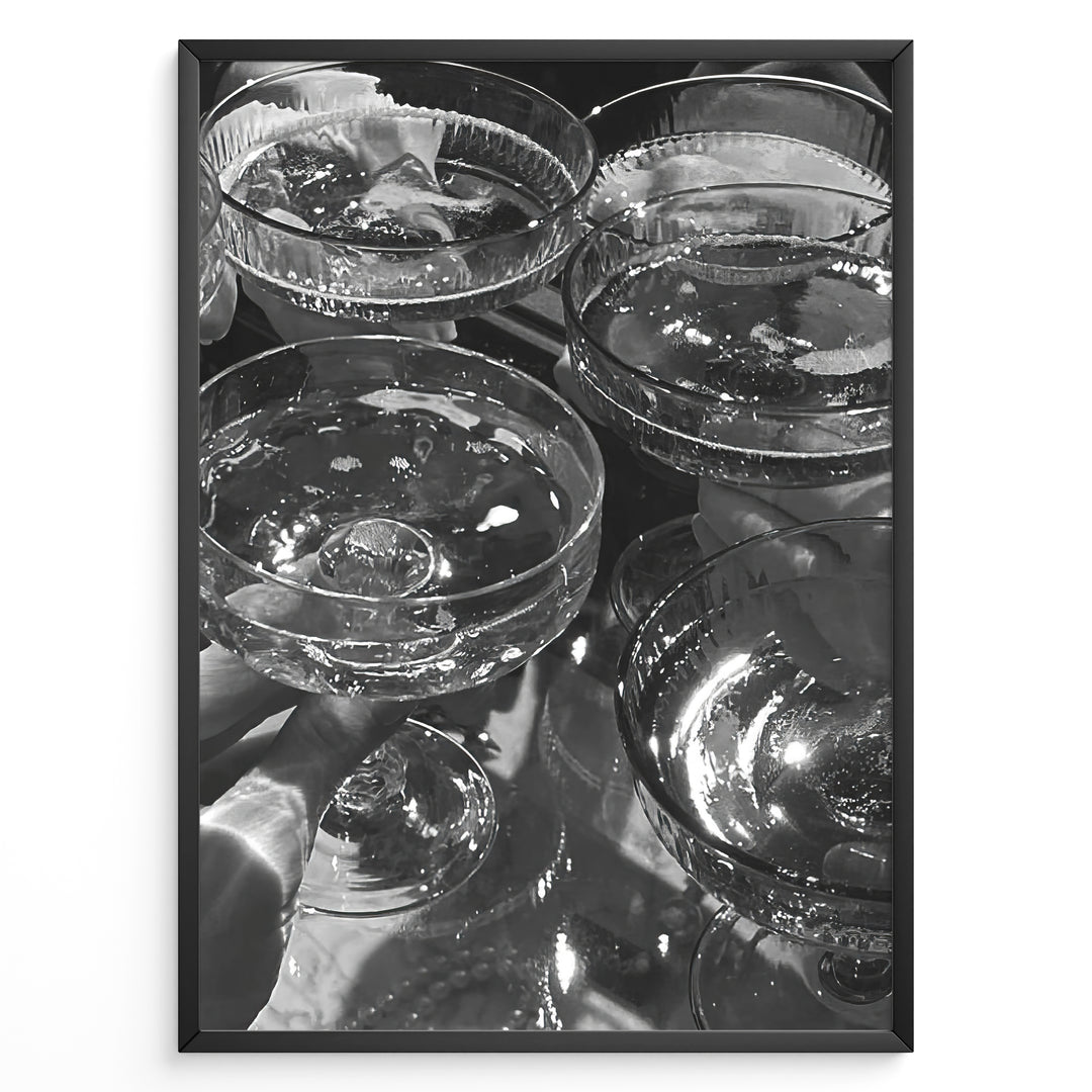Fashion Plakat | Cheers in Black & White: Luxe Champagne Coupes Wall Art Plakaty.dk | Black and white photo of multiple champagne coupe glasses being raised in a celebratory toast, reflecting light and bubbles.