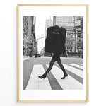 Indlæs billede til gallerivisning Fashion Plakat | Chic Chanel Street Style Fashion Print Plakaty.dk | Black and white photo of a stylish woman in heels crossing a city street while carrying a Chanel garment bag, framed as wall art.
