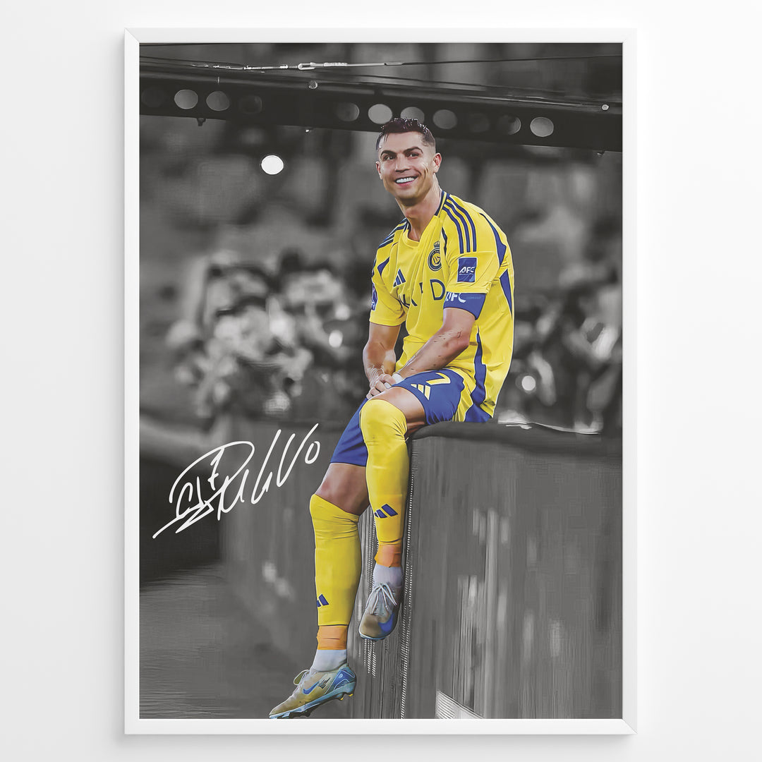 Cristiano Ronaldo sitting on barrier wearing Al Nassr yellow jersey framed plakat