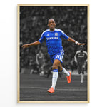 Indlæs billede til gallerivisning Didier Drogba i Chelsea-trøje med armene strakt ud under en fodboldfejring. Motivet har en sort-hvid stadionbaggrund med fremhævede blå og orange farver.
