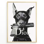 Indlæs billede til gallerivisning Fashion Plakat | Dior Guard Dog – Bold Fashion Art Print Plakaty.dk | Black and white image of a Doberman dog holding a handgun in its mouth, wearing a spiked collar with the Dior logo, against a plain background.

