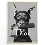 Indlæs billede til gallerivisning Fashion Plakat | Dior Guard Dog Poster – Bold Fashion Statement Wall Art Plakaty.dk | Black and white image of a Doberman dog holding a handgun in its mouth, wearing a Dior collar, with &quot;Dior&quot; text overlayed – a bold, edgy luxury fashion print.
