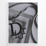 Indlæs billede til gallerivisning Fashion Plakat | Dior Pendant Necklace – Elegant Black &amp; White Fashion Print Plakaty.dk | Black and white close-up image of a Dior pendant necklace with a metallic chain, showcasing luxury jewelry on a textured background.
