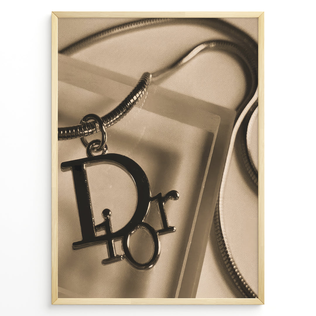 Fashion Plakat | Dior Sepia Necklace Charm – Vintage-Inspired Fashion Wall Art Plakaty.dk | Sepia-toned Dior necklace charm with close-up detail on a textured surface, styled as vintage fashion wall art.