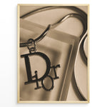 Indlæs billede til gallerivisning Fashion Plakat | Dior Sepia Necklace Charm – Vintage-Inspired Fashion Wall Art Plakaty.dk | Sepia-toned Dior necklace charm with close-up detail on a textured surface, styled as vintage fashion wall art.
